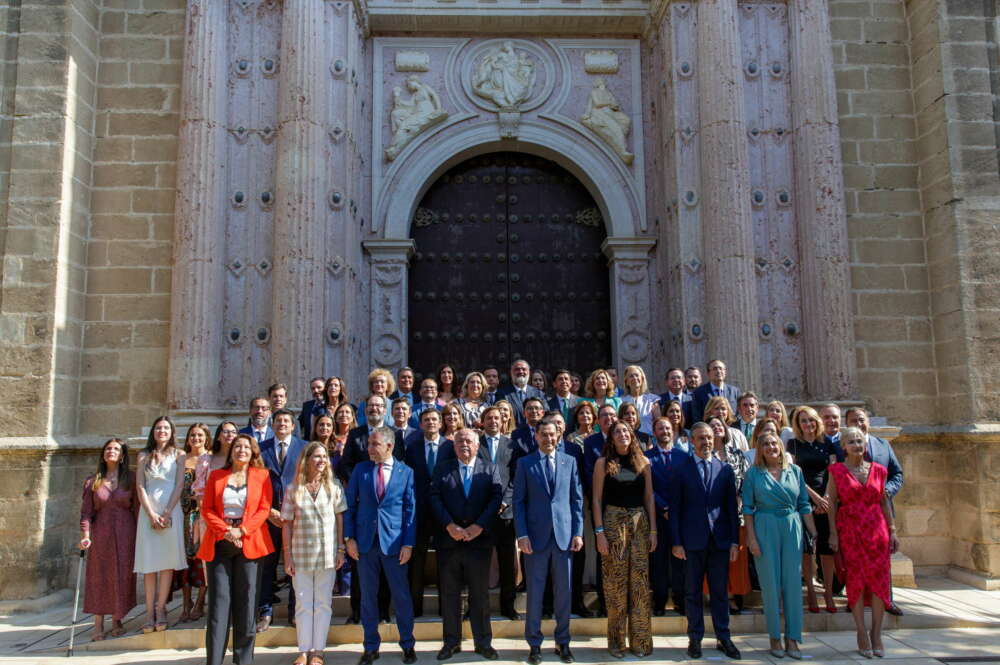 GRAFAND1588. SEVILLA, 14/07/2022.- El presidente de la Junta en funciones, Juanma Moreno, posa con los diputados populares a las puertas del salón de plenos hoy jueves, día en el que se constituye el Parlamento en la XII legislatura de la autonomía andaluza y por primera vez en la historia el PP tendrá mayoría absoluta lo que dará paso a un rápido proceso de renovación institucional que finalizará en diez días con la formación del nuevo Ejecutivo de Juanma Moreno. EFE/Julio Muñoz