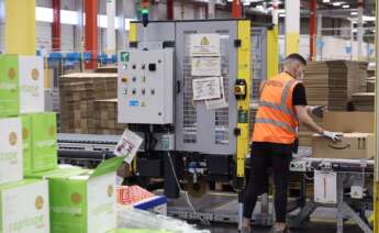 Un trabajador prepara un pedido, en una caja de cartón, en las instalaciones del Centro Logístico de Amazon.