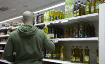 Una persona compra aceite en un supermercado.