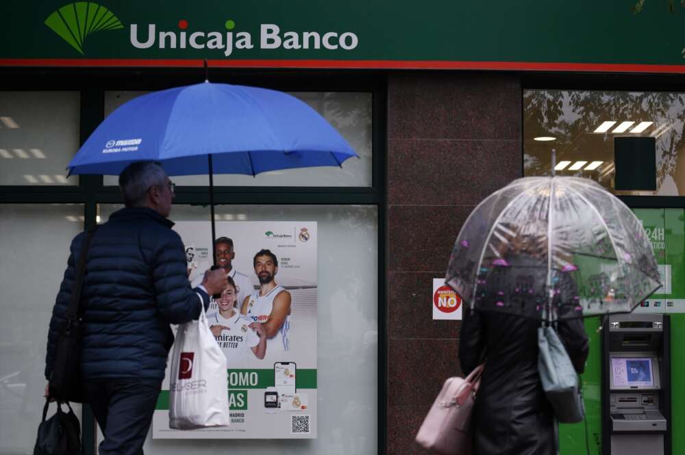 Una mujer saca dinero de un Unicaja Banco.