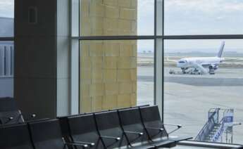 Detalle de una terminal del Aeropuerto de Sevilla con un avión estacionado en mitad de la pista.