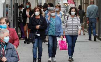 Varias personas con mascarilla caminan por la calle de Viveiro, Lugo. /EFE