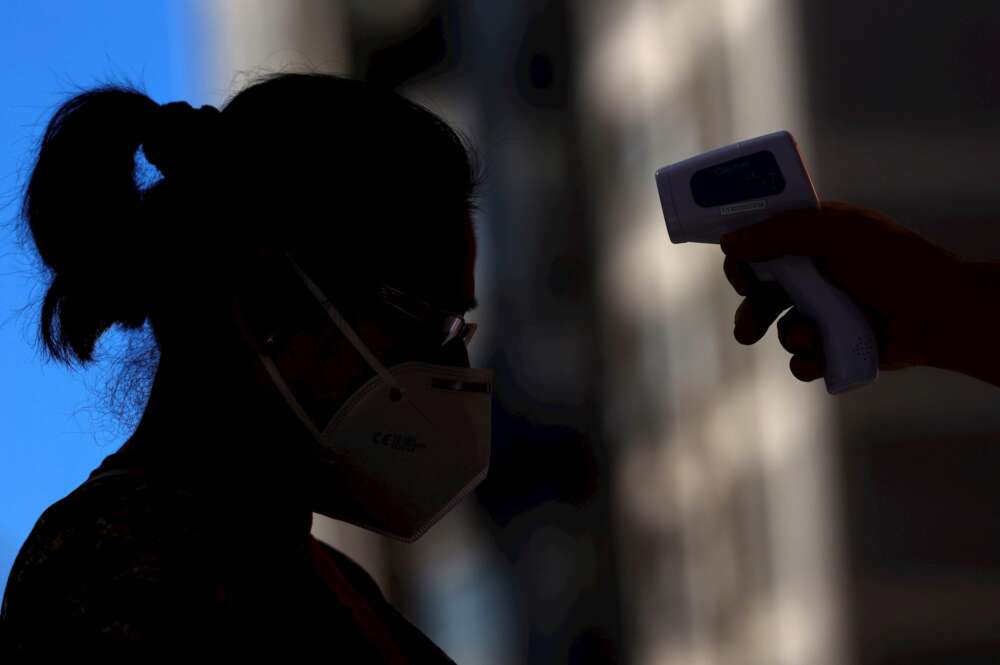 Un sanitario toma la temperatura a una mujer. EFE/Mariscal/Archivo