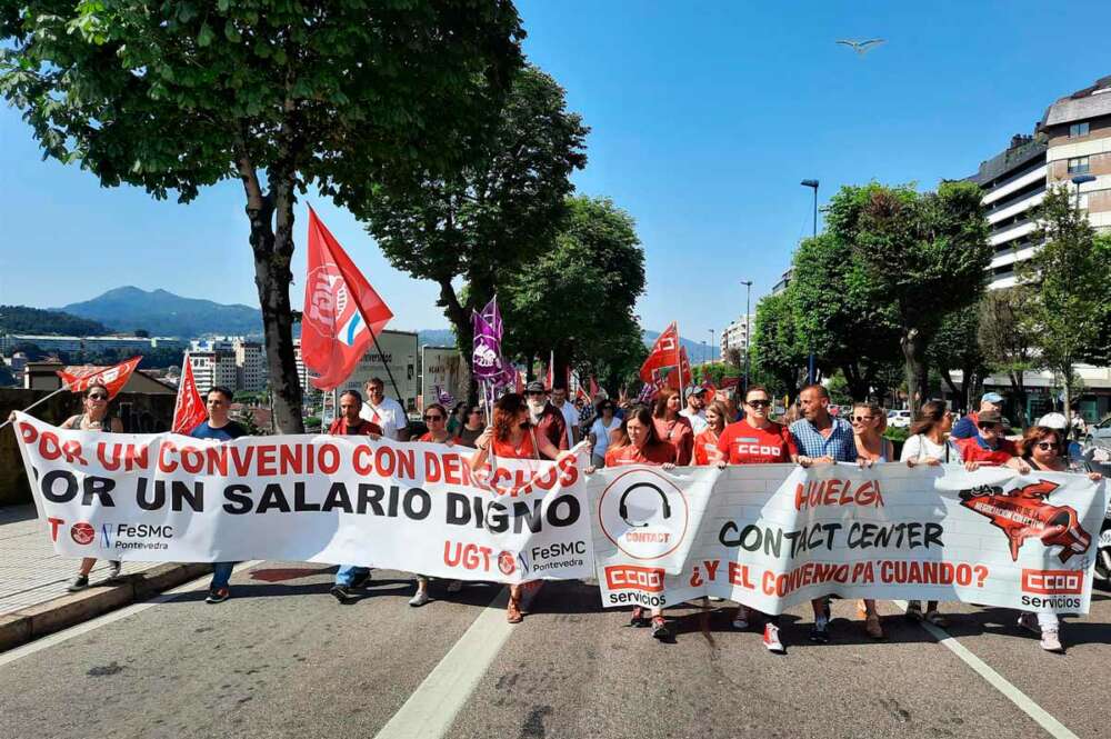 Empleados del sector contact center portando una pancarta en una manifestación en las calles de Vigo