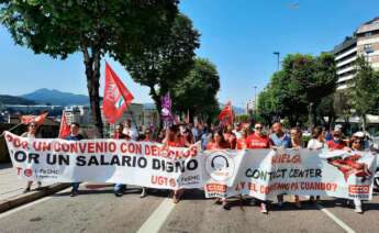 Empleados del sector contact center portando una pancarta en una manifestación en las calles de Vigo