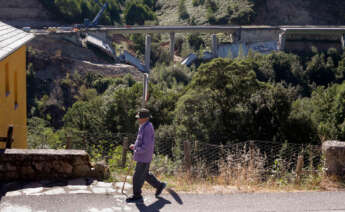 Operarios y grúas trabajan durante el desmontaje del tercer y último vano del viaducto de la A6