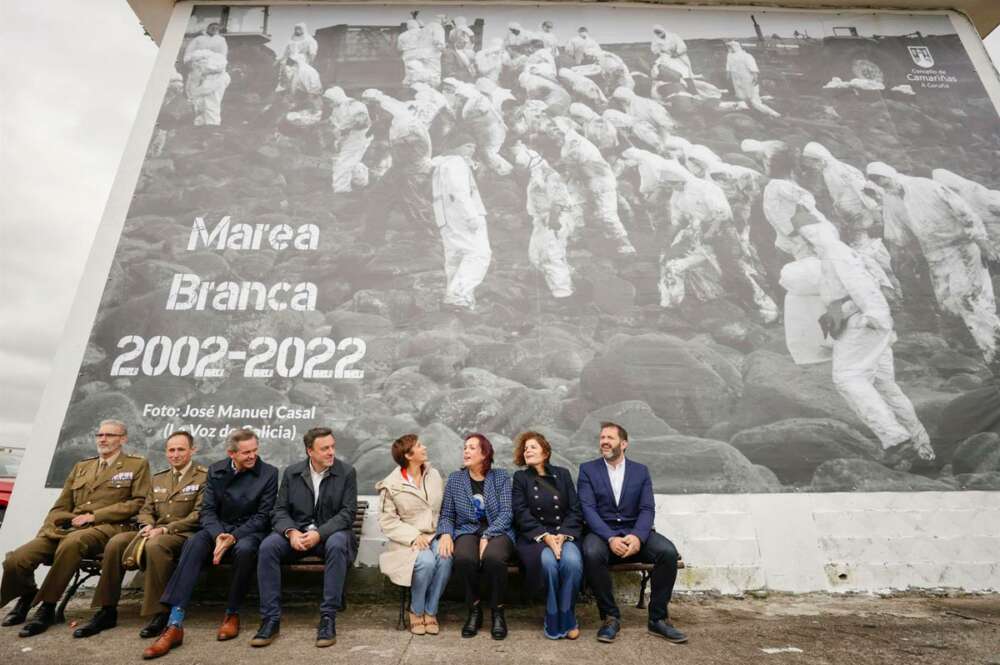 La ministra de Política Territorial y portavoz del Gobierno, Isabel Rodríguez (4d), durante el acto 'Marea Branca 2002-2022', homenaje de la Costa da Morte a los voluntarios que limpiaron las playas y rocas gallegas del chapapote que dejó el Prestige hace veinte años, evento en el que ha quedado instalada una lona de grandes dimensiones con una fotografía en recuerdo de aquellos voluntarios