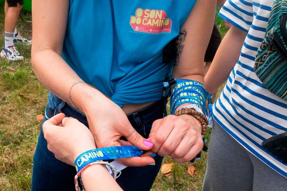 Una chica pone una pulsera en la zona de acampada en el festival Oson de Camiño, en el Monte do Gozo, a 15 de junio de 2022, en Santiago de Compostela