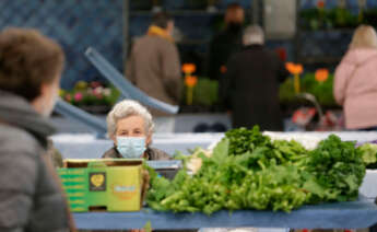 Una mujer en un puesto local de verduras y productos del campo de Lugo