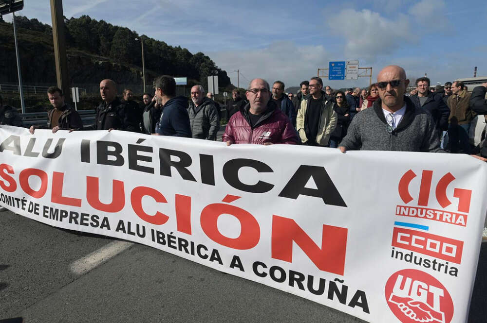 Un grupo de personas protesta con una pancarta durante una concentración frente a la fábrica de Alu Ibérica, a 14 de marzo de 2023, en A Coruña, Galicia