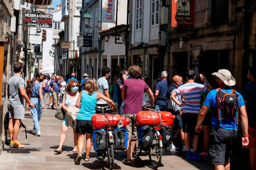 Varios peregrinos caminan por las calles de Santiago