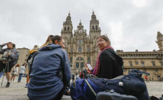 Dos turistas sentadas en la Praza do Obradoiro de Santiago / EFE