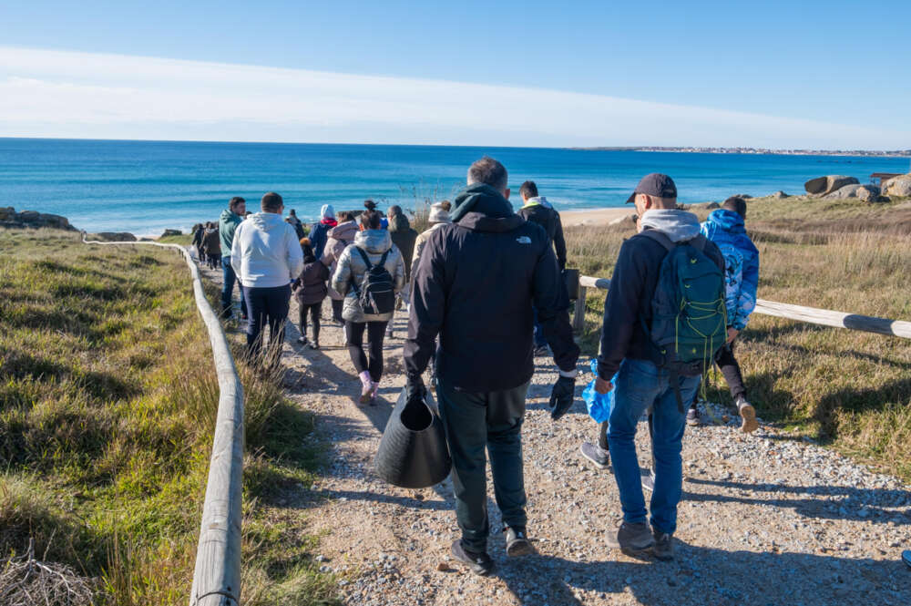 Voluntarios llegando a la playa de O Vilar para una jornada de limpieza tras la llegada de miles de bolitas de plástico procedentes del Tocomao / EFE/ Xurxo Martínez