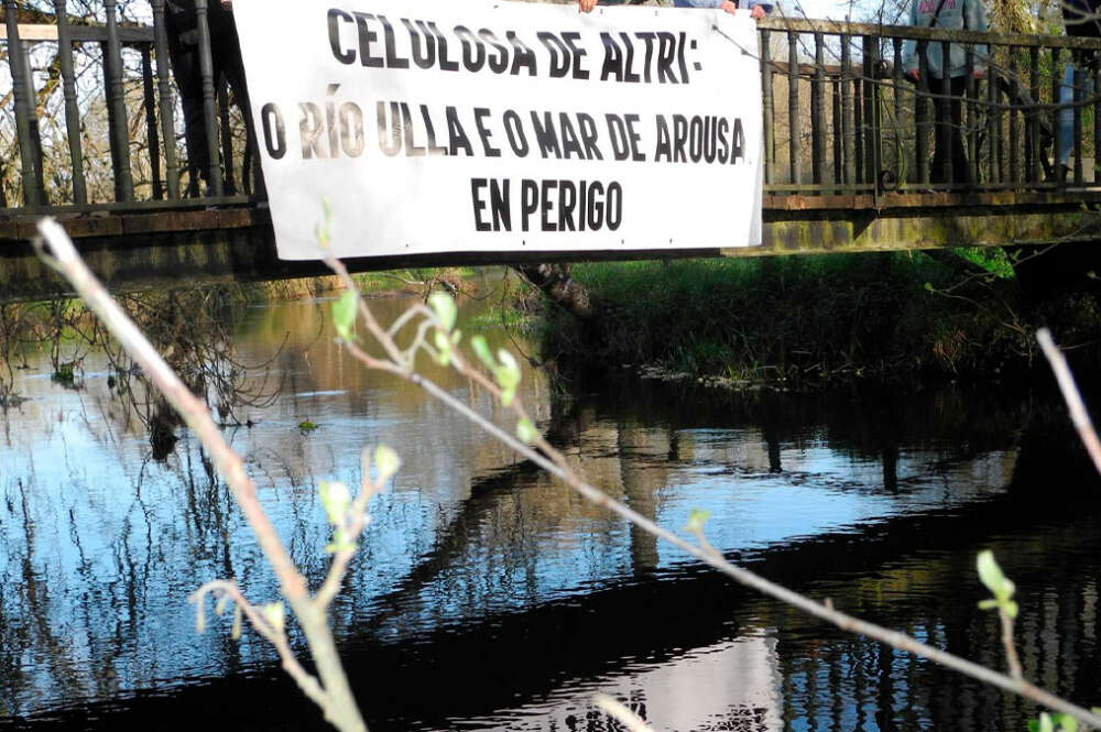 Pancarta en contra de Altri en un puente sonbre el río Ulla a su paso por Monterroso