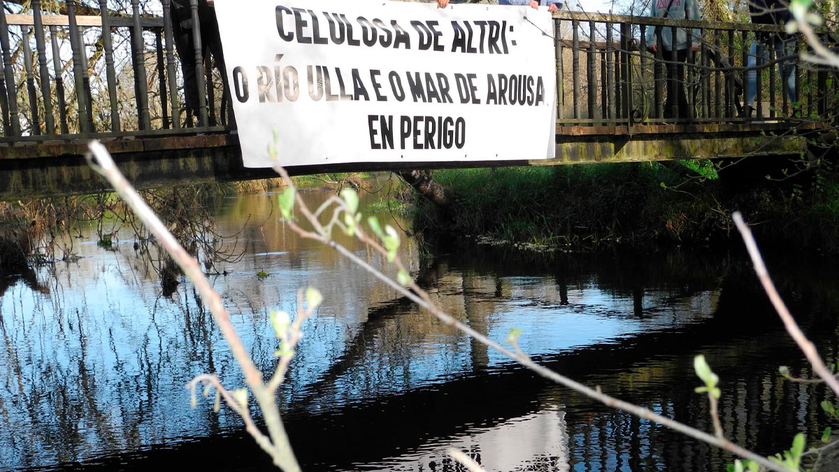 Pancarta en contra de Altri en un puente sonbre el río Ulla a su paso por Monterroso