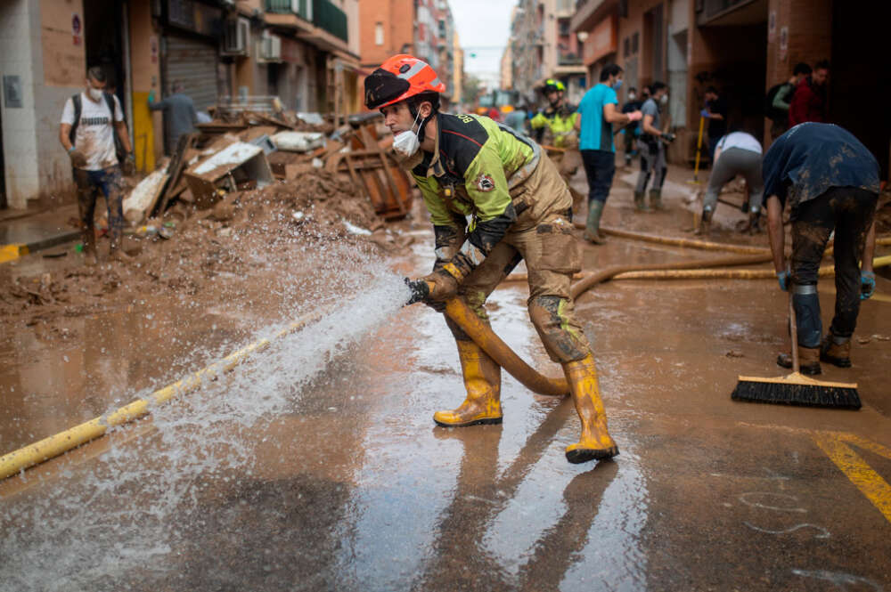 Un bombero sujeta una manguera de extracción, a 4 de noviembre de 2024, en Benetússer, Valencia