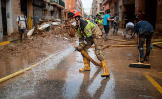 Un bombero sujeta una manguera de extracción, a 4 de noviembre de 2024, en Benetússer, Valencia