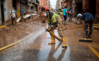 Un bombero sujeta una manguera de extracción, a 4 de noviembre de 2024, en Benetússer, Valencia