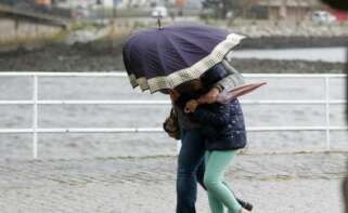 Dos personas caminan con dificultad por el viento en Viveiro como consecuencia del temporal / Europa Press