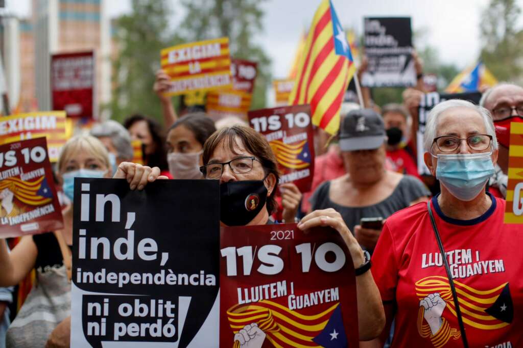 GRAF4106. BARCELONA, 03/10/2021.- Varias personas muestran carteles en una manifestación convocada por la ANC para conmemorar el referéndum unilateral del 1-O, en vísperas de que el expresident Carles Puigdemont vuelva a Cerdeña para declarar ante el juez. EFE/Marta Pérez