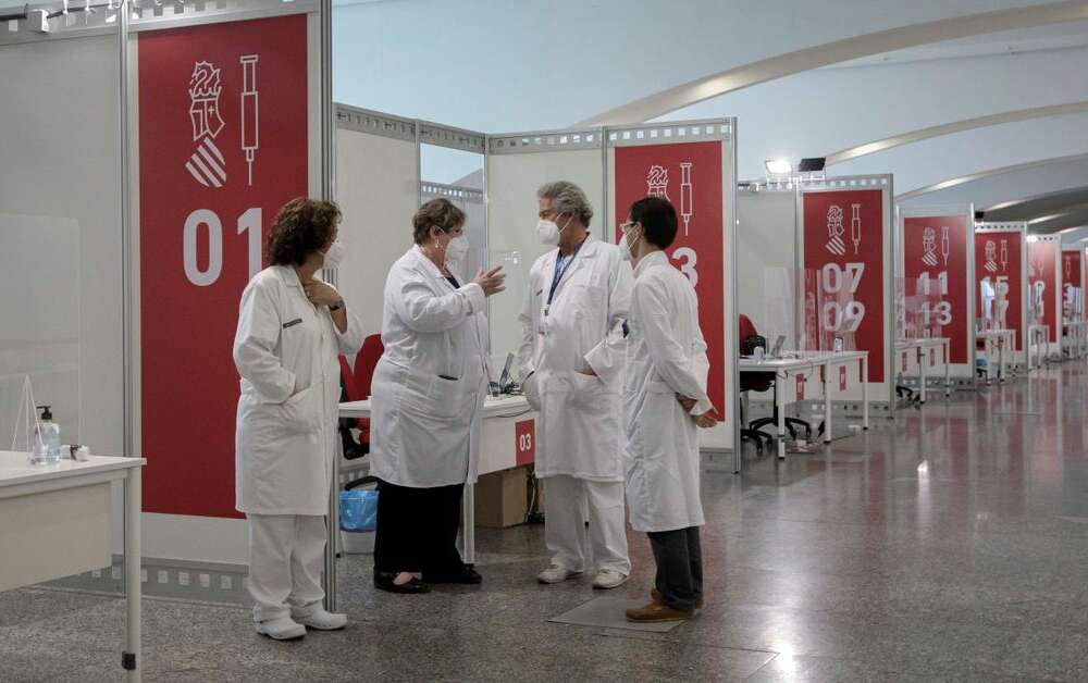 Varios sanitarios conversan este sábado en el punto de vacunación masiva de Valencia situado en la Ciudad de las Artes y las Ciencias. EFE/Biel Aliño