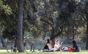 Varias personas descansan en el Jardín del Turia (Valencia), en el antiguo cauce del río. EFE/ Kai Forsterling