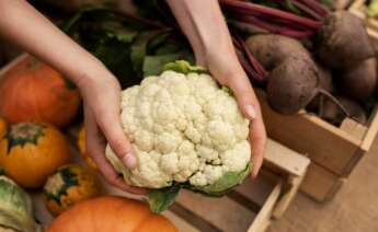 Una persona sostiene una coliflor. Foto: Freepik.