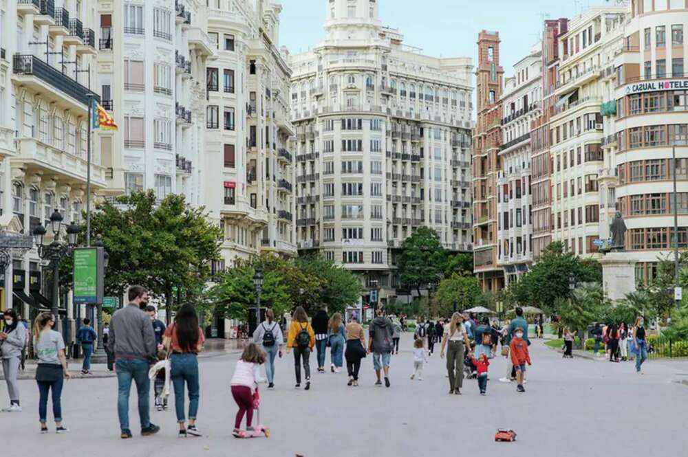 Gente que está paseando por la plaza del Ayuntamiento de Valencia.