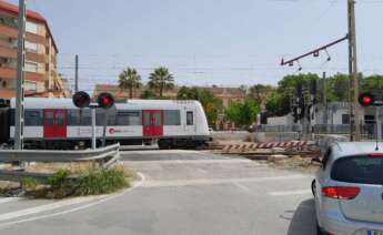 Un cruce de vías en la que aparece un coche y un metro de Metrovalencia en la localidad de Paterna (Valencia)