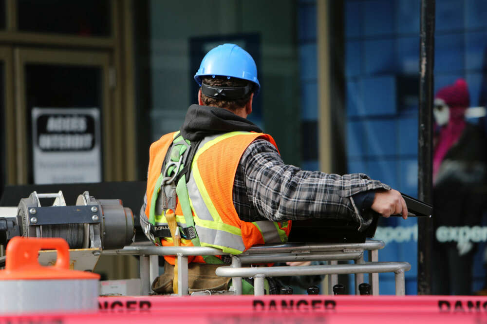 Hombre de espaldas en una elevadora hidráulica que representa un trabajo peligroso para sufrir un accidente