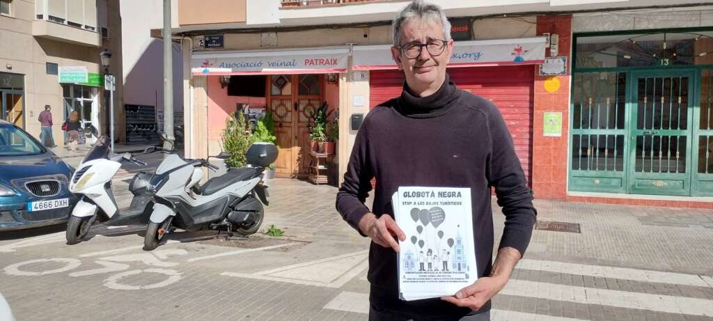 Miguel Roig, presidente de la comunidad de vecinos de Patraix sosteniendo el cartel de la manifestación