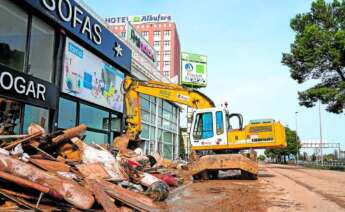 Una grau recogiendo escombros de una empresa afectada por la DANA en Valencia