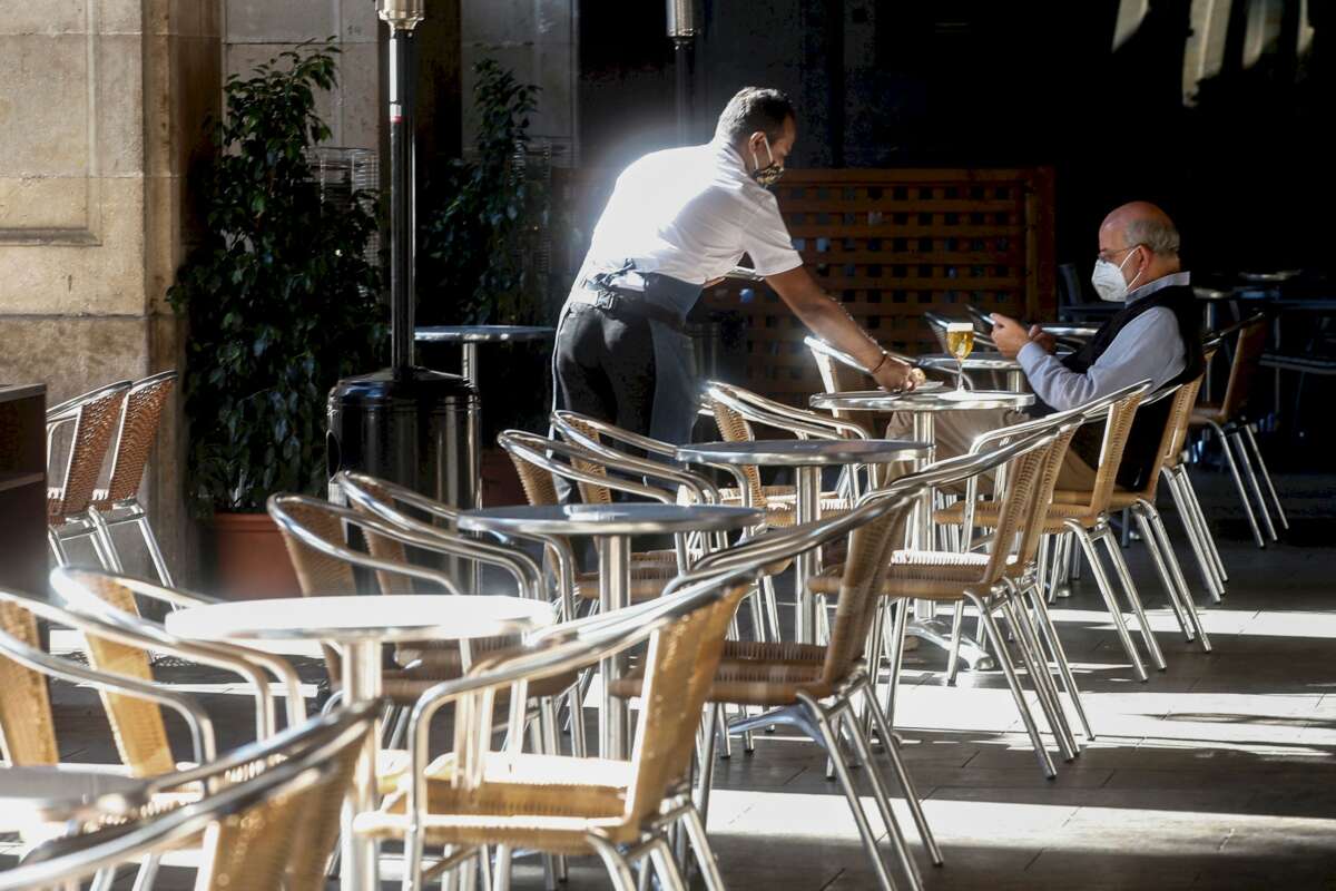 Un camarero atiende a un cliente, este miércoles, en un local de la Plaza Real de Barcelona. /EFE/Quique Garcia