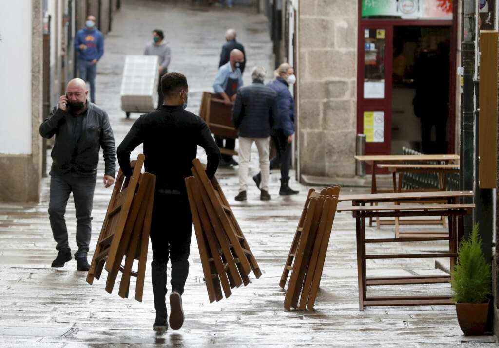 Un camarero monta una terraza en una calle de Santiago de Compostela, uno de los sectores más afectados por la crisis económica en España. EFE/Lavandeira jr