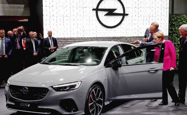 La canciller alemana, Angela Merkel, observa el Opel Insignia GSI junto al primer ejecutivo de Opel Michael Lohscheller. | EFE