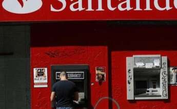 Un cliente saca dinero de un cajero del Banco Santander