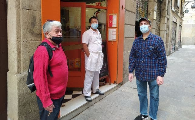 El encargado (i) y el cocinero (c) de la pizzería San Marino, de la calle Ciutat, conversan con Josep (d), otro cocinero del barrio. /ED