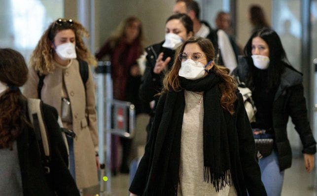 Viajeros procedentes de Italia protegidos con mascarillas a su llegada al aeropuerto de Manises (Valencia)./ EFE