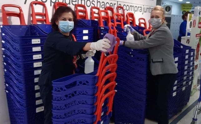 Empleados de Carrefour desinfectan los carros de la compra para evitar contagios por coronavirus.