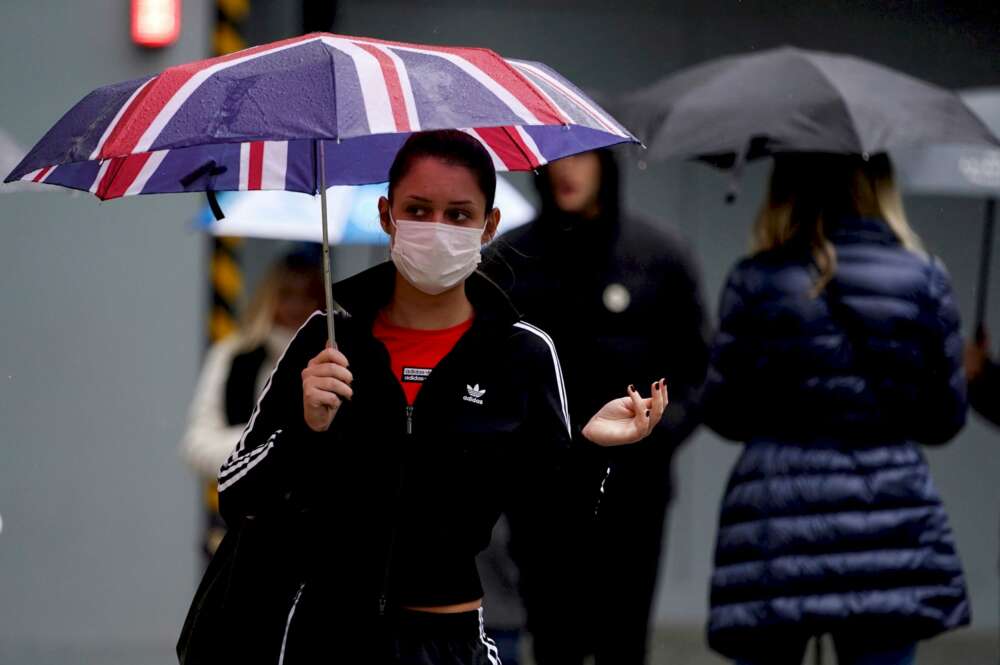 Varias personas pasean por las calles de Reino Unido con mascarillas de protección contra la Covid-19 / EFE