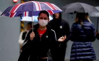 Varias personas pasean por las calles de Reino Unido con mascarillas de protección contra la Covid-19 / EFE