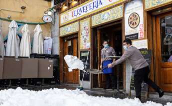 Personal de hostelería limpian de nieve las terrazas de los establecimientos en Madrid, este domingo. EFE/Rodrigo Jiménez