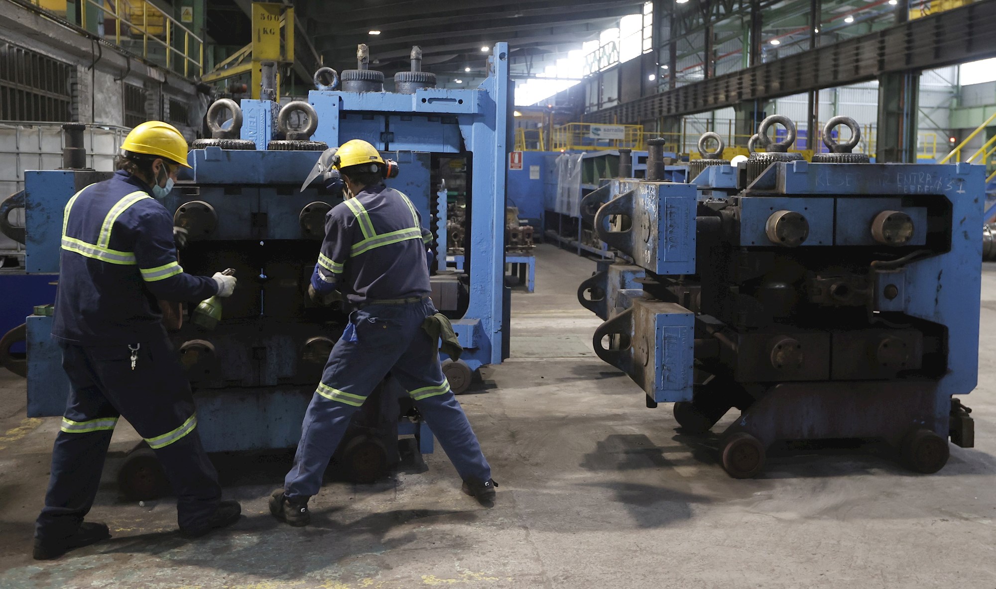 Dos trabajadores ante una máquina en las instalaciones de Sidenor, en Bizkaia. EFE/LUIS TEJIDO