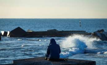 Una persona observa el mar en la playa de Somorrostro este sábado, momento en el que la tercera ola de la epidemia de COVID sigue aumentando en Cataluña./ EFE