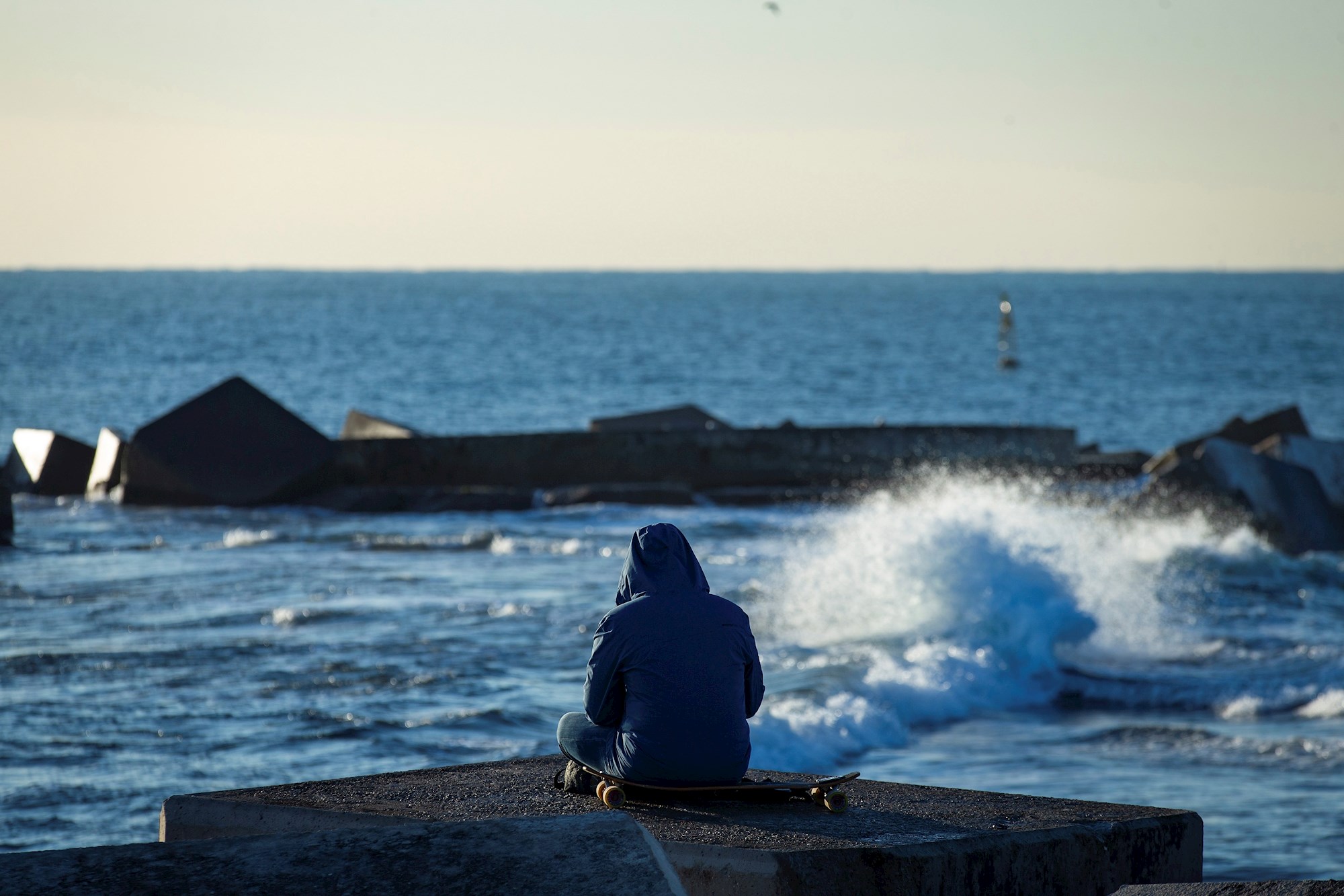 Una persona observa el mar en la playa de Somorrostro este sábado, momento en el que la tercera ola de la epidemia de COVID sigue aumentando en Cataluña./ EFE