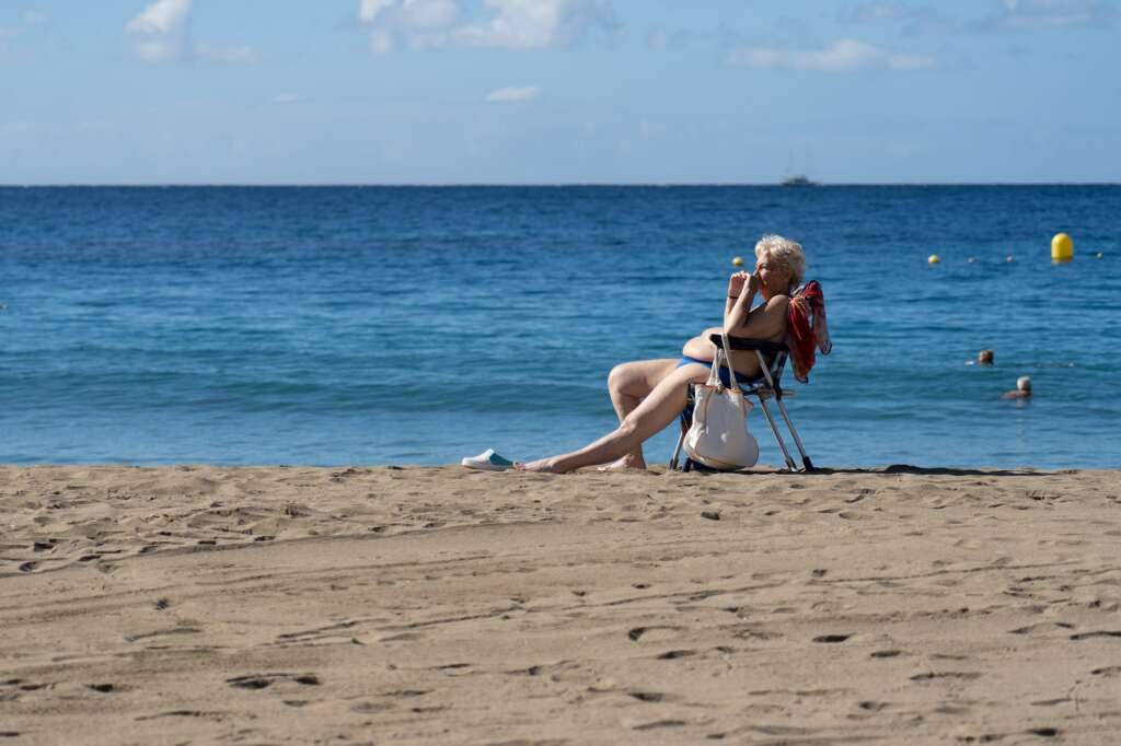 Unos turistas disfrutan de las buenas temperaturas en la playa de Las Vistas en la localidad de Los Cristianos (sur de Tenerife). EFE/Ramón de la Rocha/Archivo