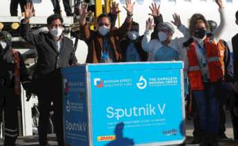 El presidente de Boliva, Luis Arce, (2i) saluda junto a un contenedor con dosis de la vacuna rusa Sputnik V el 28 de enero de 2021, en el Aeropuerto Internacional de El Alto (Bolivia). EFE/Martin Alipaz