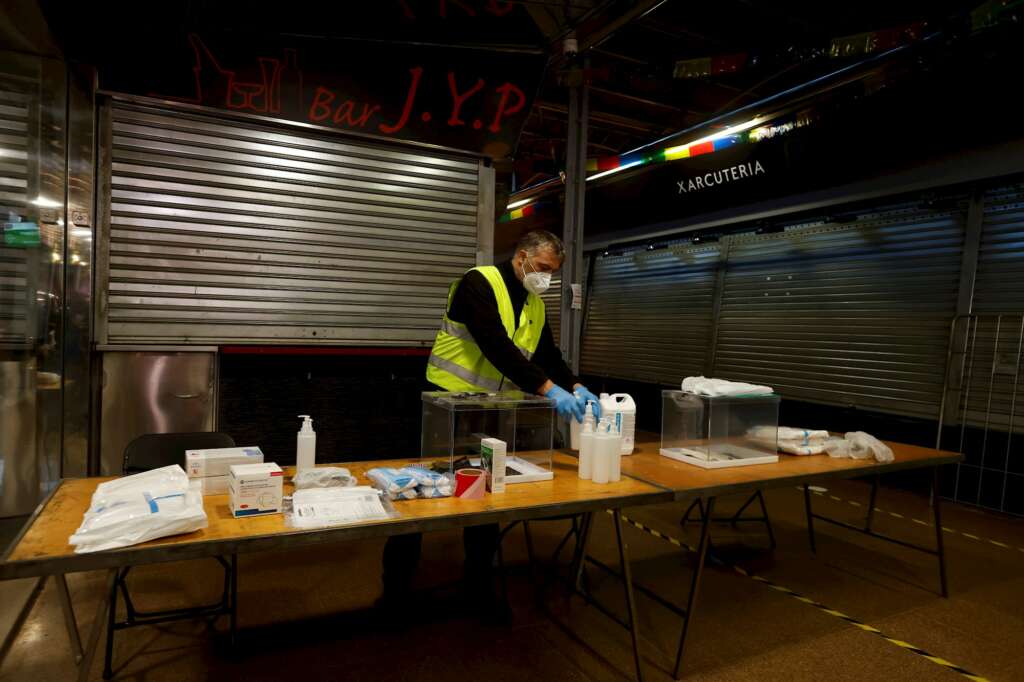 Un operario procede a colocar las mesas, cabinas y urnas del 14-F en el Mercado del Ninot de Barcelona, el 10 de febrero de 2021 | EFE/QG