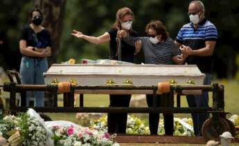 Una familia despide a un familiar durante un entierro en Brasilia (Brasil). EFE/ Joédson Alves.