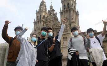 Turistas asiáticos posaban en la plaza compostelana del Obradoiro el Jueves Santo. EFE/ Xoán Rey/Archivo